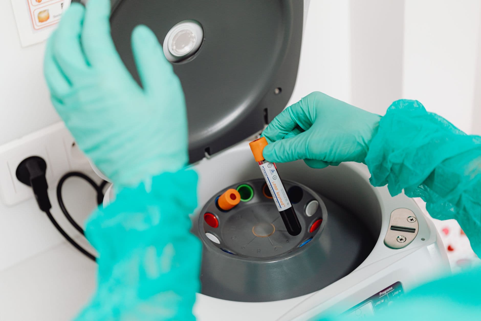 Lab technician using a centrifuge for blood analysis