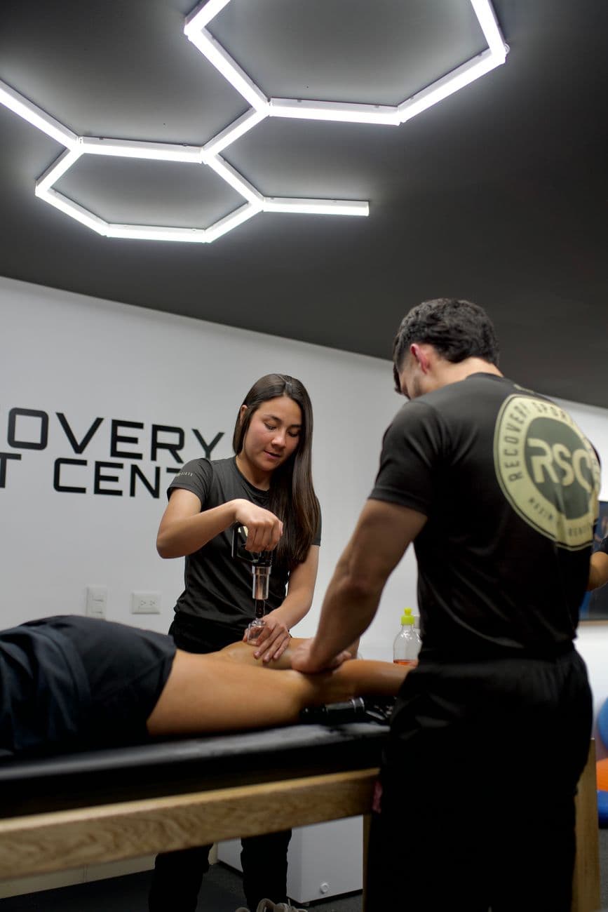 Therapists treating a patient with specialised clinic equipment