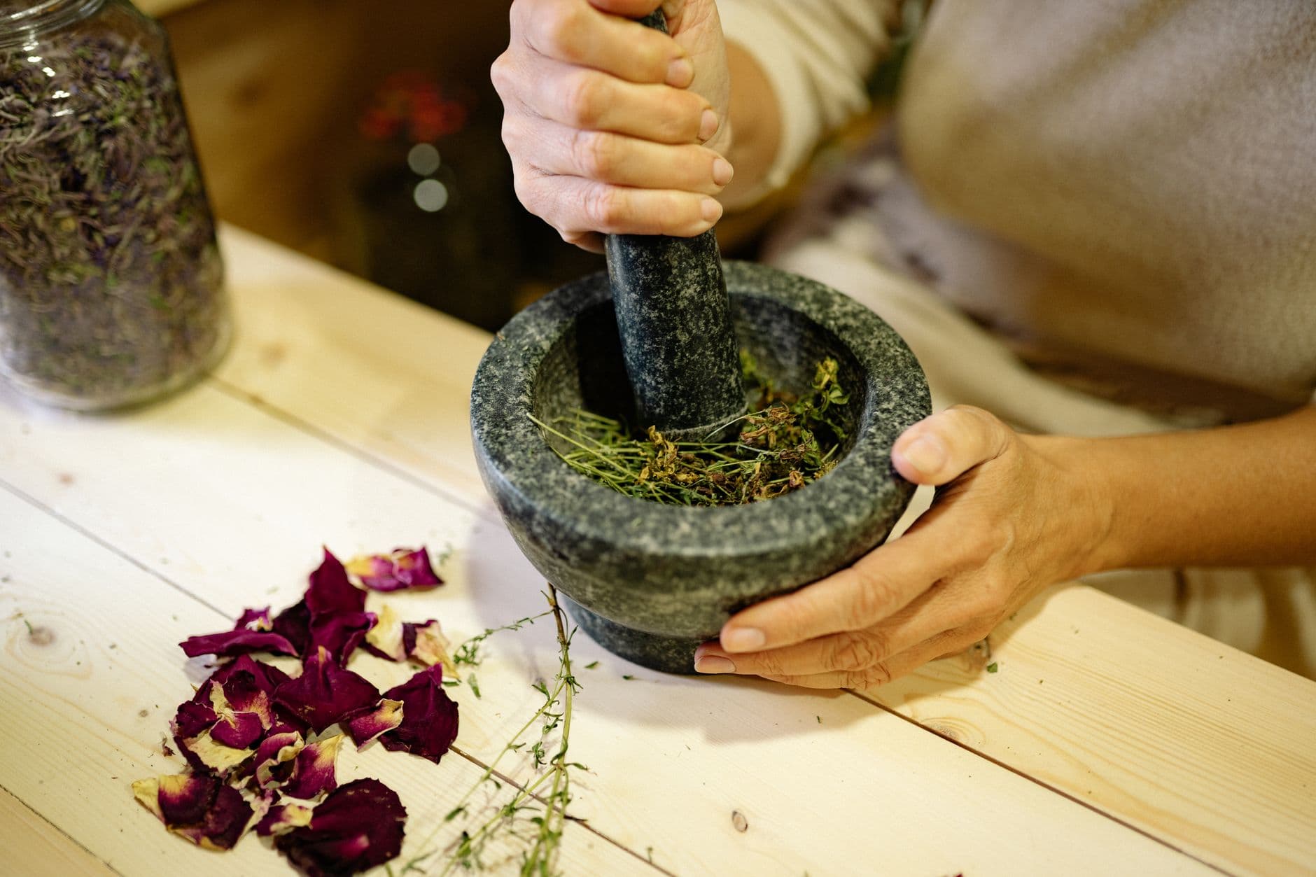Grinding herbal ingredients in a stone mortar